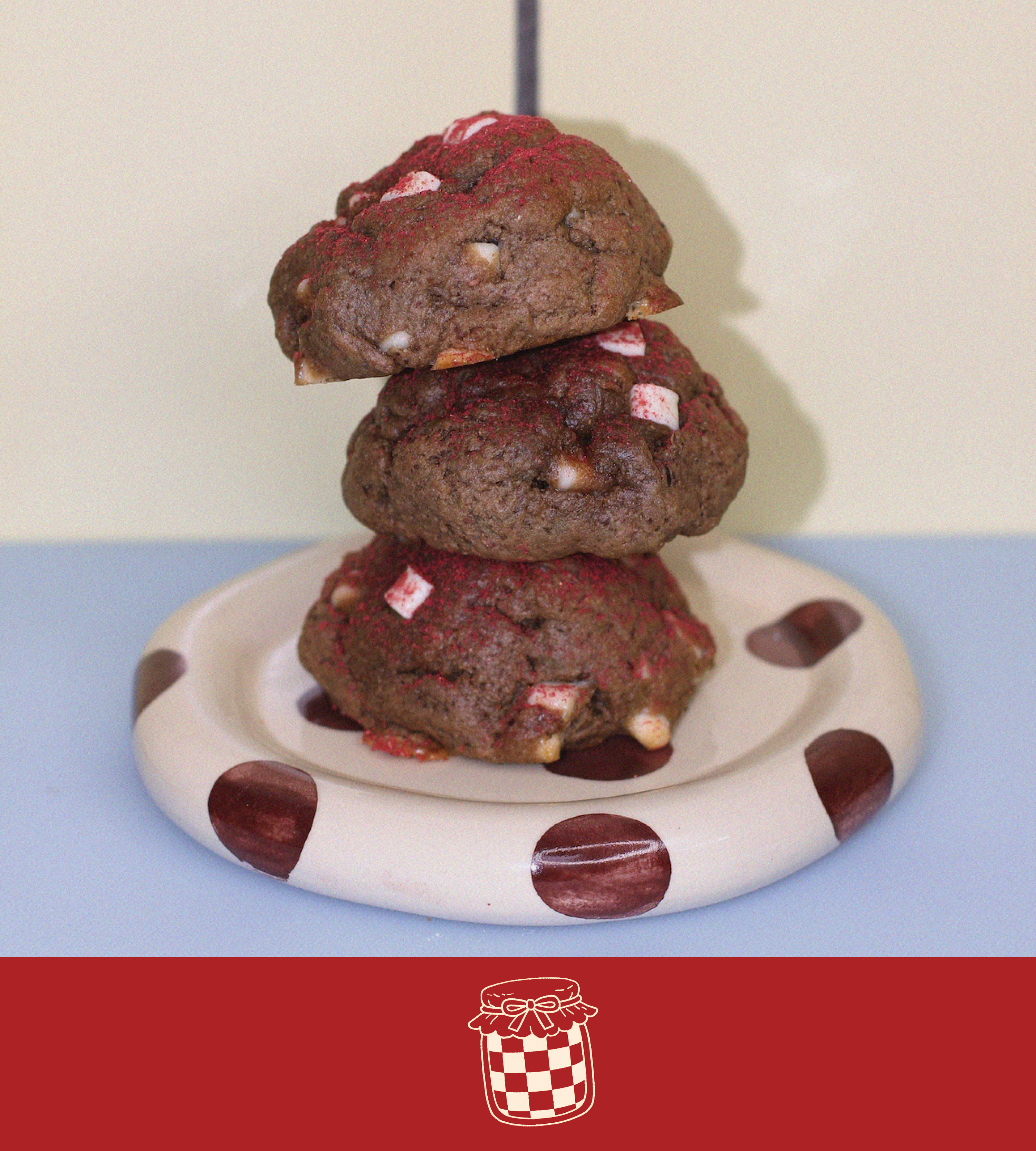 Stack of raspberry white chocolate lactation cookies on a polka dot plate with a plain background