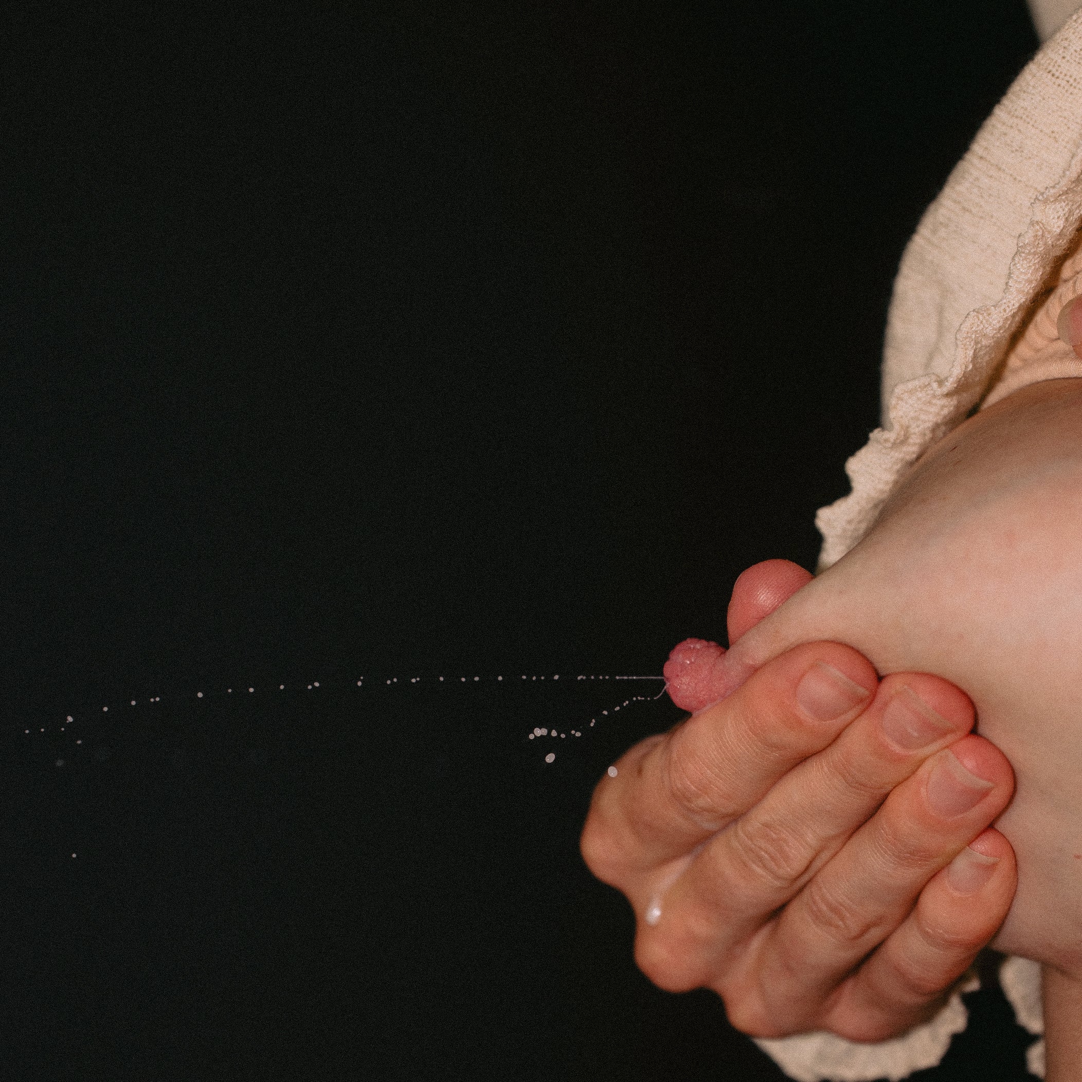 Woman hand expressing breast milk to support feeding and milk supply in the early postpartum days