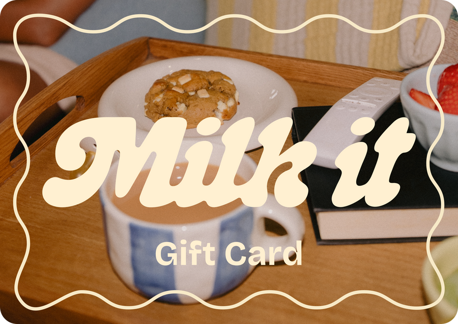 Milk it gift card design showing a cookie, cup of tea, remote and book — a cosy gift moment