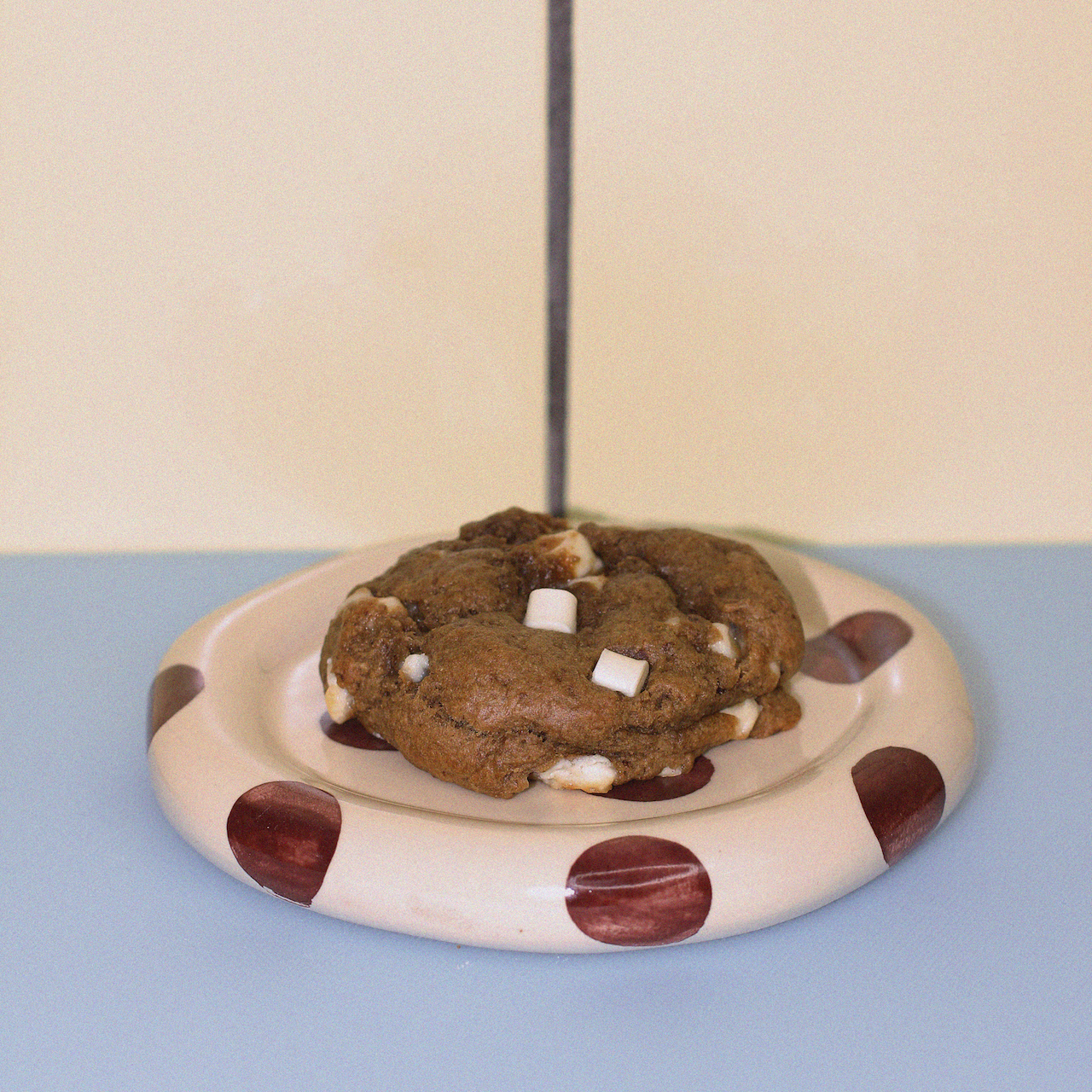 lactation cookie with real banana, white chocolate and custard powder against a butter yellow tiled wall