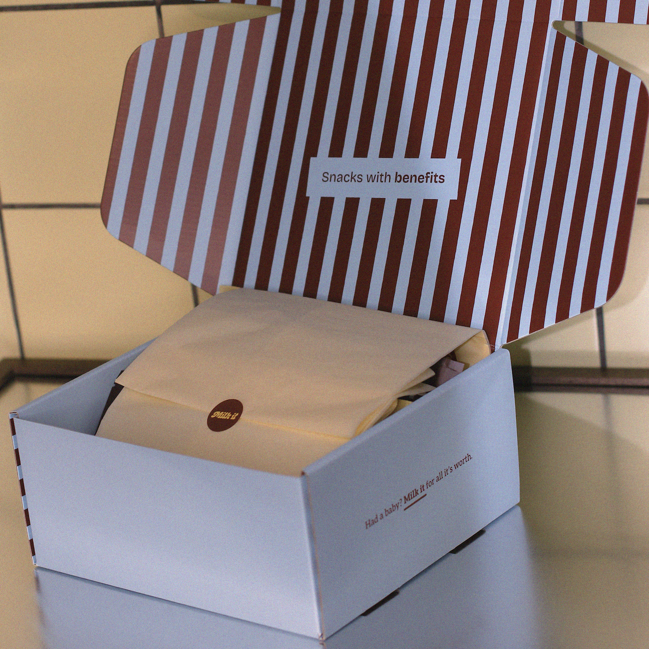 Striped box of lactation support cookies wrapped with butter yellow tissue