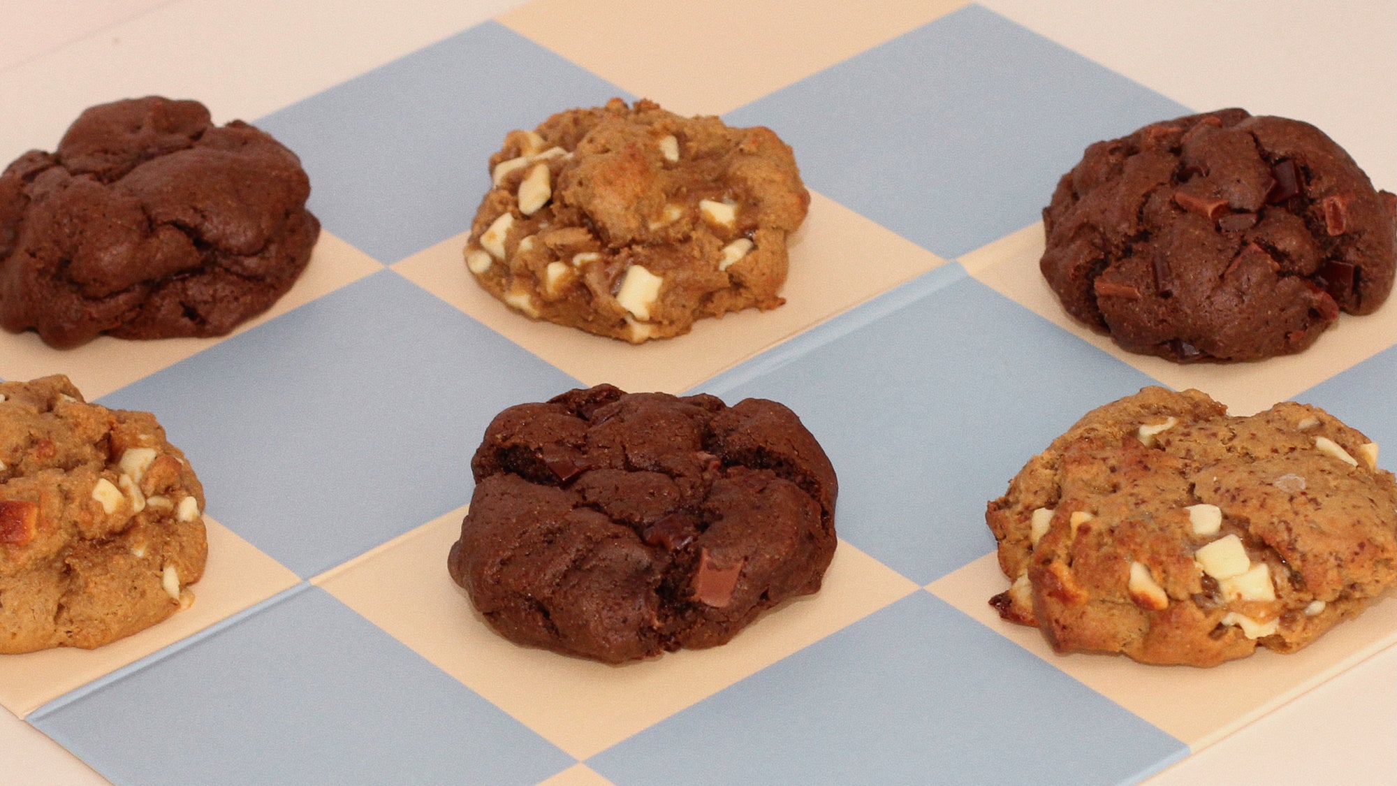 Milk it lactation cookies for breastfeeding mums on a blue and beige checkerboard background. 