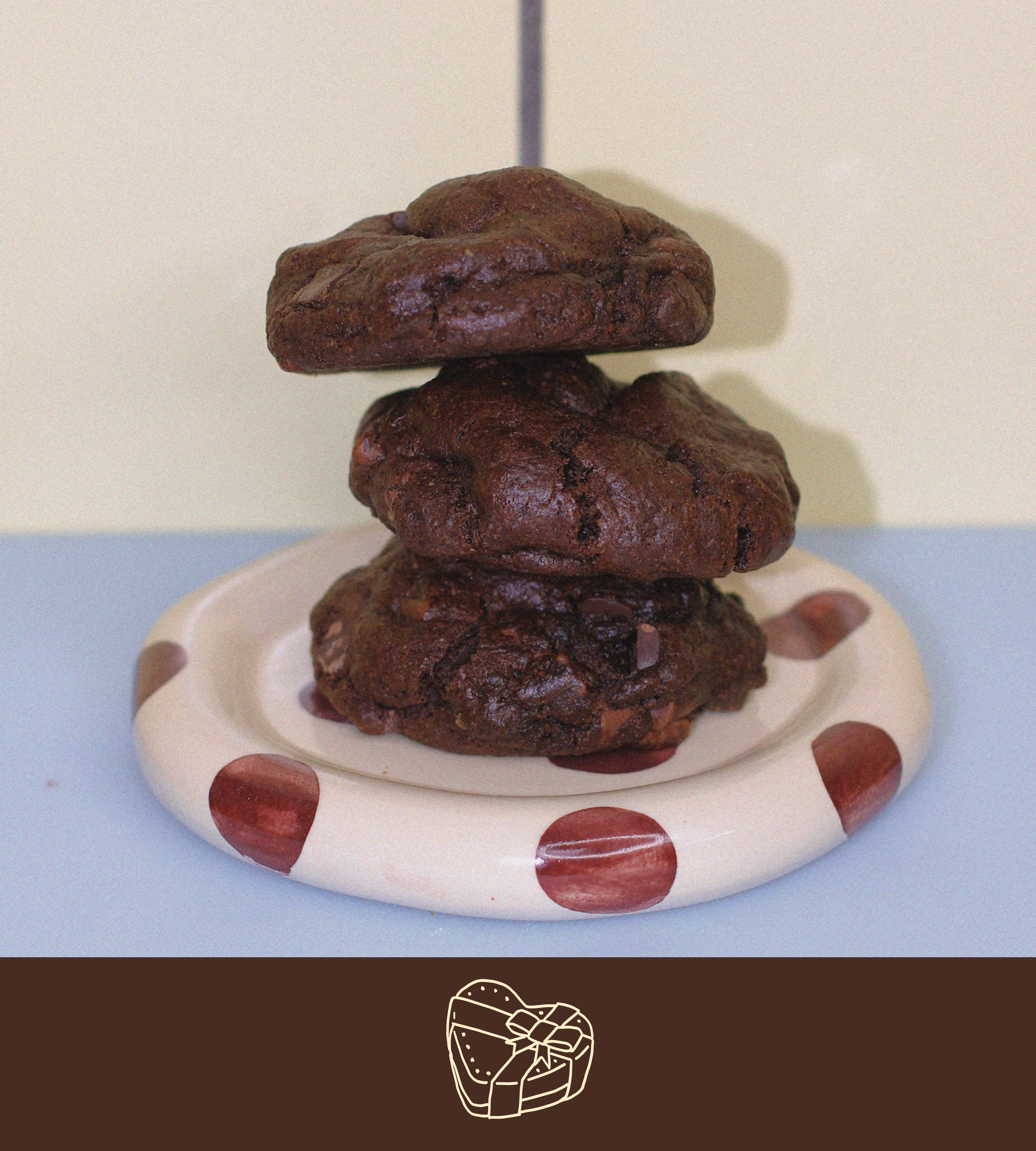 Stack of triple chocolate chunk lactation cookies on a polka dot plate with a plain background