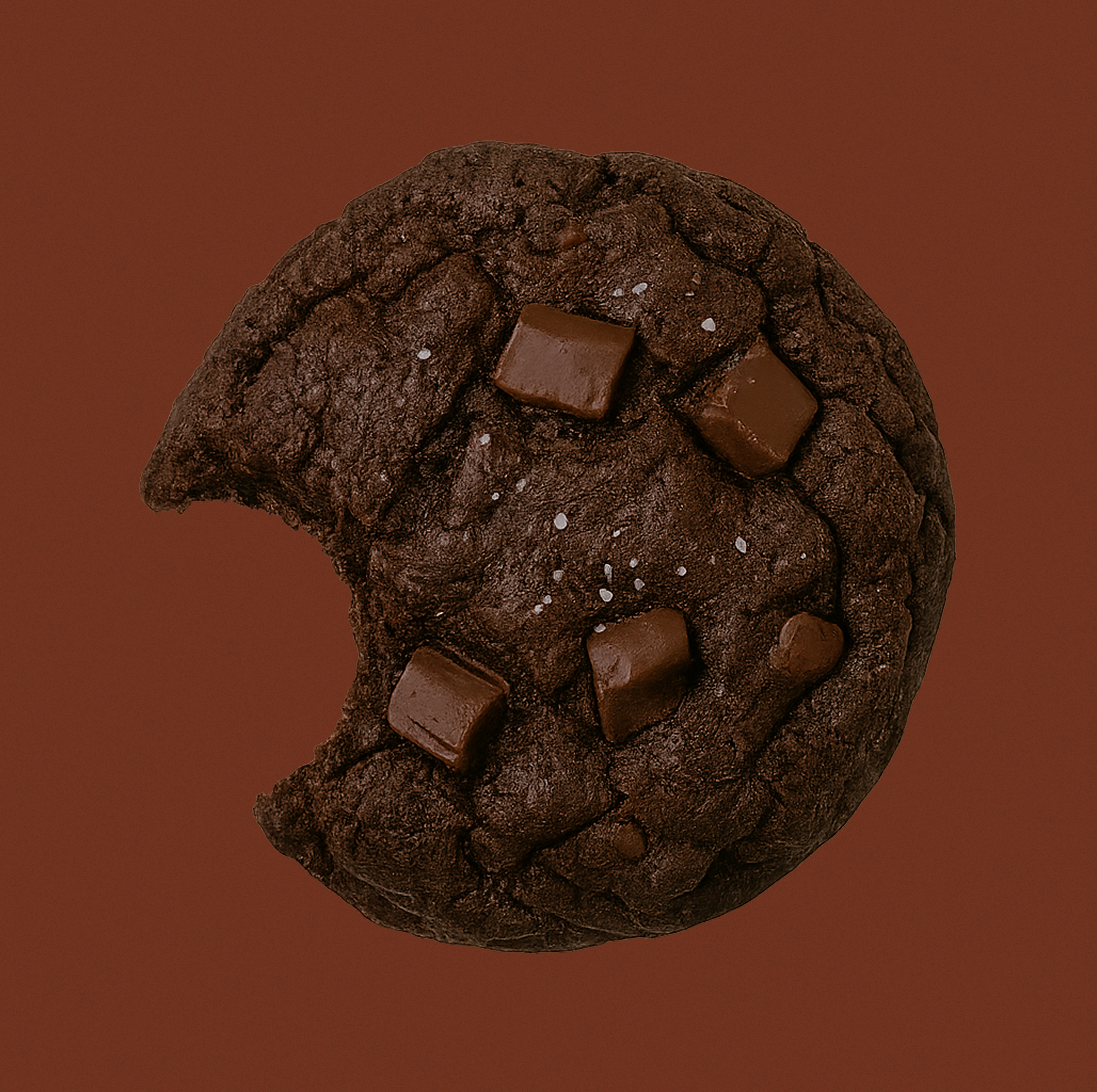 Triple chocolate chunk lactation cookie with sea salt and a bite taken out – supports milk supply and postpartum energy