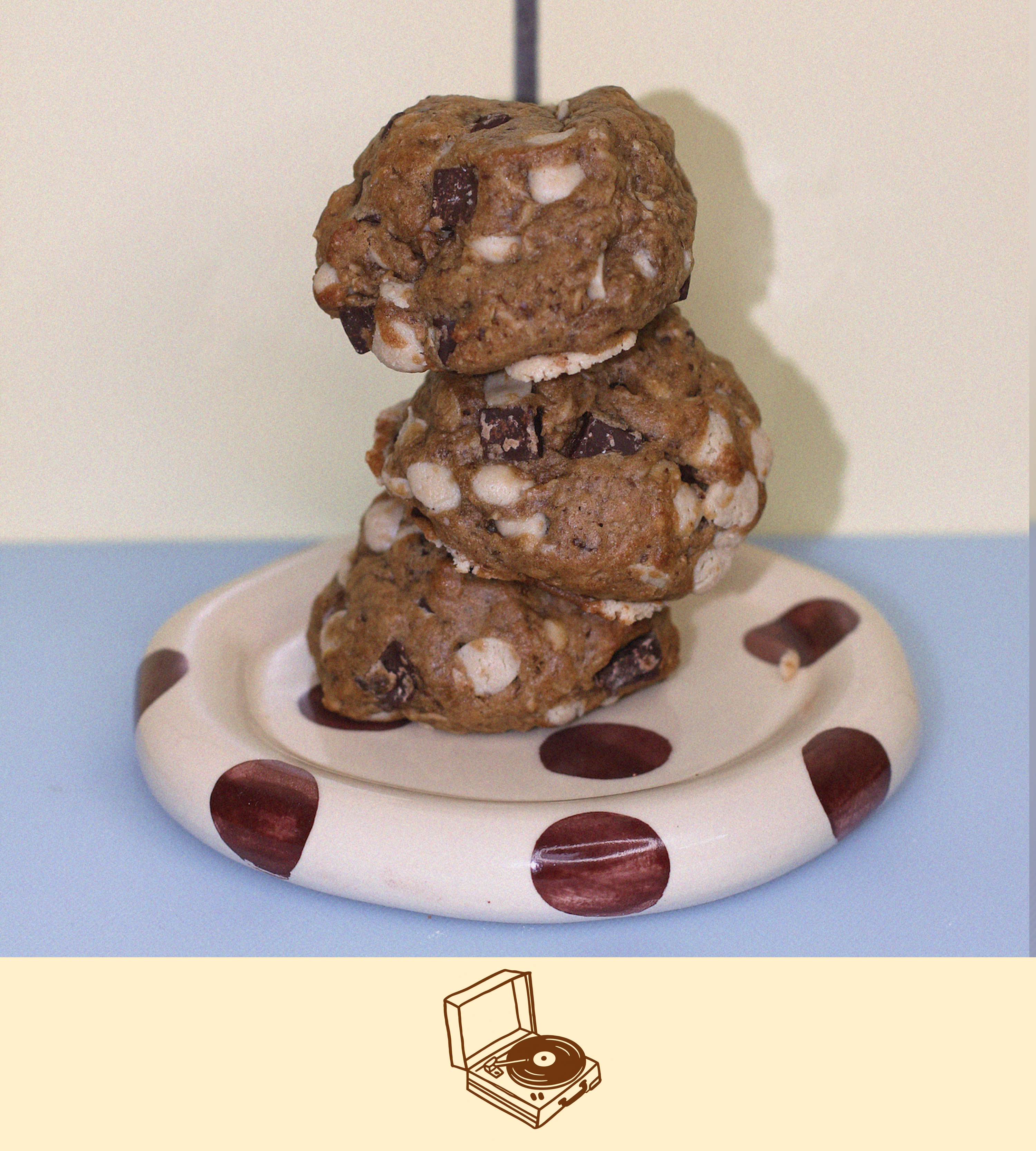 a stack of vegan latctation cookies on a polka dot plate with dark chocolate and blonde oat chocolate throughout